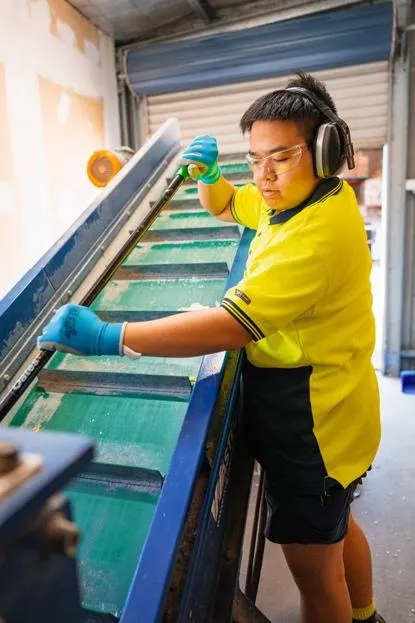 Hone supported worker working on machinery in warehouse