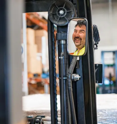 Hone supported employee smiling on forklift