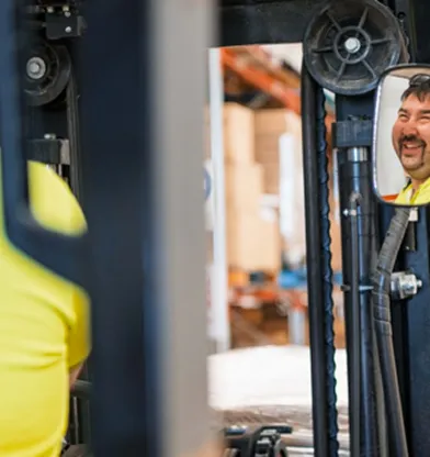 Hone supported employee smiling on forklift