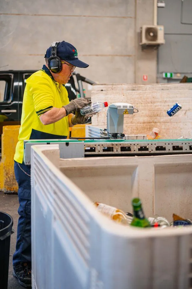 Guy, Bottle & Can Recycling worker holding a plastic bottle