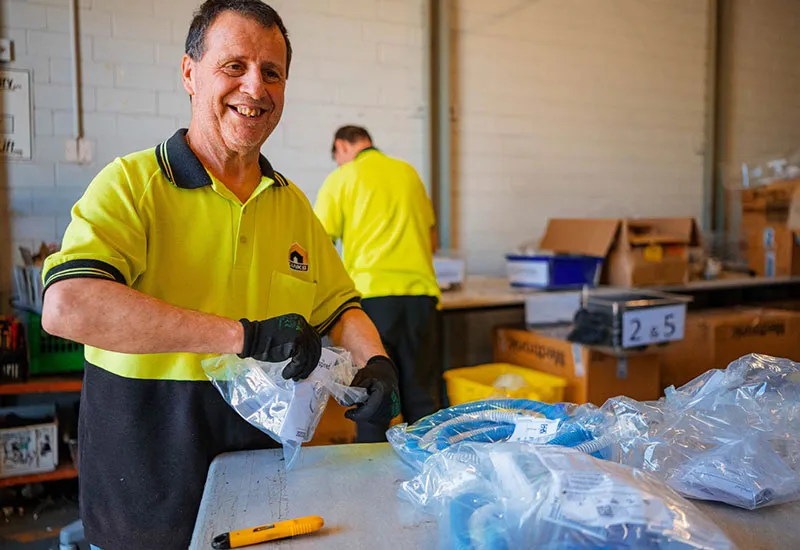 Hone employee breaking down recyclable items for destruction