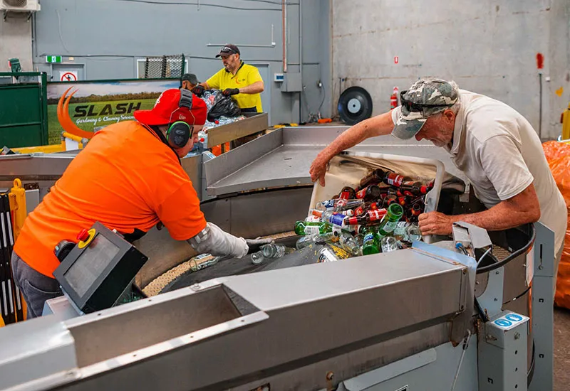 Hone's container recycling depot. Customer unloading a huge amount of containers onto conveyor belt