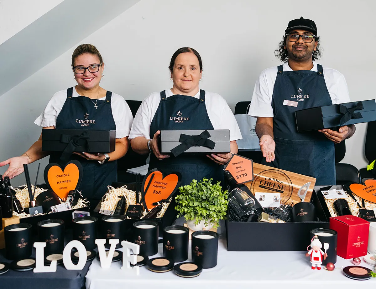 Lumiere staff holding hampers and showcasing candles